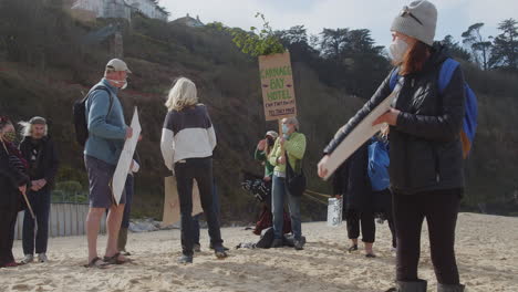 Protester-looks-around-as-demonstrators-gather-on-the-beach-in-front-of-the-Carbis-Bay-Hotel,-Cornwall