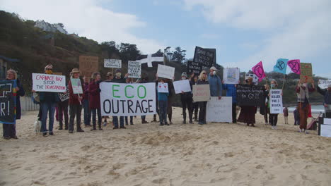 Los-Manifestantes-Se-Mantienen-Unidos-En-La-Playa-Frente-Al-Hotel-Carbis-Bay,-Cornwall.