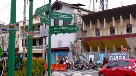 Straßennamen-Auf-Wegweiser,-Auto--Und-Motorradverkehr-Zur-Hauptverkehrszeit,-Indonesien