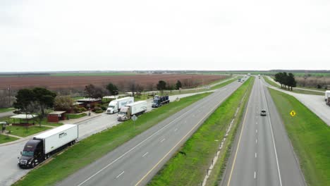 Parked-semi-trucks-in-highway-side-stop-in-aerial-orbiting-view