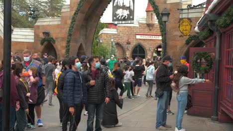 Tourists-wearing-masks-in-Hogsmeade-Village-in-Islands-of-adventure,-Orlando-Florida