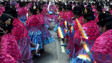 Vista-De-ángulo-Alto-De-Cholitas-Bolivianas-Desfilando-En-Trajes-Coloridos-Que-Llevan-Wiphalas