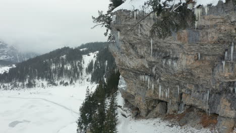 Flying-towards-icicles-hanging-of-rock-mountain-wall