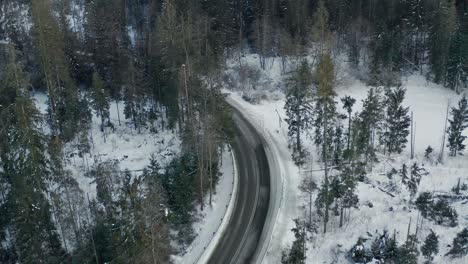 Car-driving-on-frozen-mountain-road-in-winter-season