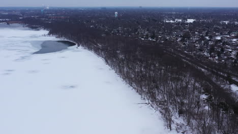 An-aerial-view-from-a-drone,-over-a-frozen-lake-during-a-cloudy-sunrise