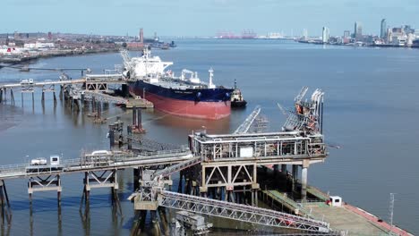 Commercial-crude-oil-tanker-ship-loading-at-refinery-harbour-terminal-aerial-view-slow-reverse