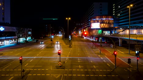 Hamburg-downtown-crossing-at-dark-night-with-light-trails-and-flashing-advertising-banners,-Time-Lapse