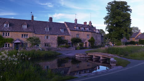 Dieses-Filmmaterial-Zeigt-Eine-Klappbrücke-über-Den-Fluss-Eye-Und-Die-Alten-Cottages-In-Lower-Slaughter,-Cotswold,-Großbritannien