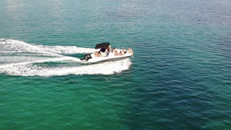 Motorboat-full-of-tourists-enjoy-sunny-Majorca-Spain-in-aerial-shot