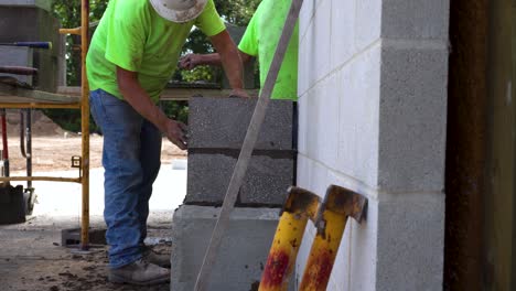 A-man-brushes-grout-off-of-a-pillar