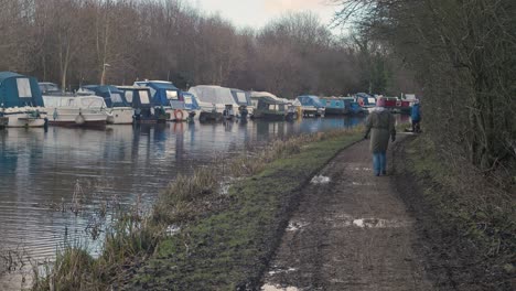 Back-view-of-people-walking-along-Castleford-canal,-West-Yorkshire-in-England