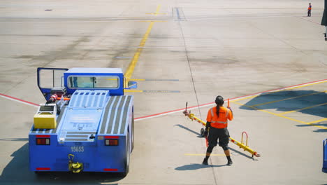 Mitarbeiter-Der-Start--Und-Landebahn-Des-Flughafens-Houston,-Der-In-Sicherheitsausrüstung-Signalstöcke-Umdreht