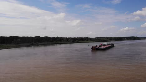 Vista-Aérea-De-La-Barcaza-Dinámica-Que-Transporta-Camiones-Y-Tractores-A-Lo-Largo-De-Oude-Maas-Cerca-De-Barendrecht