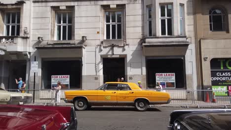 Wide-shot-of-an-American-taxi-parked-in-a-Scottish-city