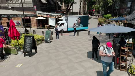 Wide-angle-aerial-dolly-out-of-public-square-at-la-Condesa-at-day