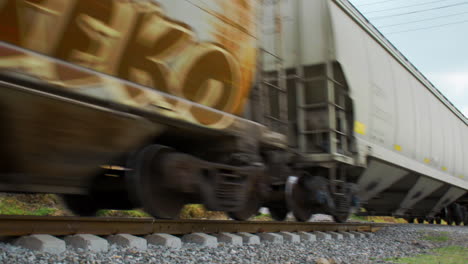Still-close-up-of-train-wagons-moving-and-rail-track-components-seen-from-below-in-Mexico-during-the-day