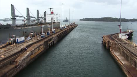 Electric-locomotives-slowly-pulling-the-Bulk-Carrier-into-the-Gatun-Locks-chamber,-Panama-Canal