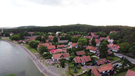 Small-town-of-Nida-and-historical-buildings,-side-aerial-flying-view