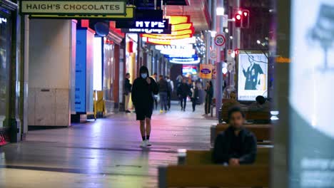 Gente-Caminando-En-La-Acera-Con-Tiendas-Por-La-Noche-En-George-Street-Con-Tranvía-En-Sydney,-Nsw,-Australia