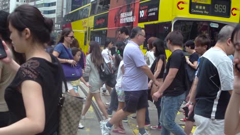 Südchinesische-Asiaten-Telefonieren-Mit-Ihrem-Handy,-Während-Sie-Einen-Zebrastreifen-überqueren,-Während-Der-Bus-Causeway-Bay-969-Hält