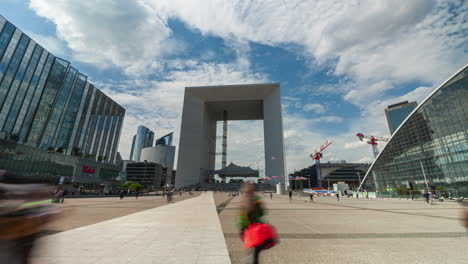 La-Defense-Grande-Arche-Zeitraffer-Mit-Cnit-Und-Einkaufszentrum-Mit-Menschen,-Die-An-Einem-Sonnigen,-Bewölkten-Tag-Schnell-Vorbeilaufen