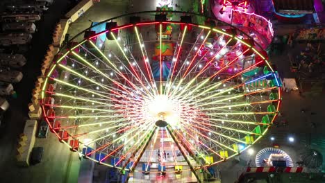 An-aerial-view-above-the-colorful-ferris-wheel-in-Santa's-Enchanted-Forest-at-night