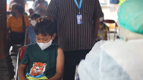 Yogyakarta,-Indonesia---Dec-20,-2021-:-an-elementary-school-boy-is-receiving-the-covid-19-vaccine