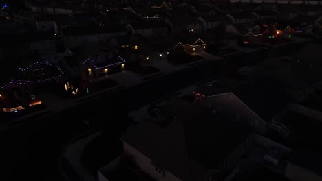 Flying-over-a-suburban-neighborhood-on-Christmas-night-and-seeing-houses-decorated-with-colorful-lights