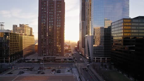 Drone-Aerial-View-Flying-Through-Downtown-Denver-Colorado-Showing-Traffic,-Streets-And-Avenues-During-Golden-Hour-Sunset