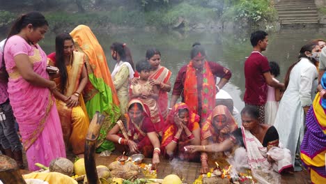 Blick-Auf-Das-Indische-Volk,-Das-Während-Der-Hinduistischen-Hochzeit-Rituale-Mit-Früchten,-Feuer-Und-Blumen-Vor-Dem-Wasser-Des-Ganga-Flusses-Durchführt