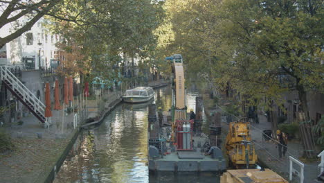 Trabajadores-De-La-Construcción-Que-Trabajan-Desde-Un-Barco-Pontón-Con-Grúa-En-Un-Hermoso-Canal-Holandés