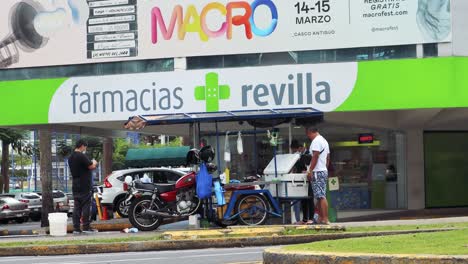 Un-Hombre-Parado-Frente-A-La-Tienda-Médica,-Avenida-Balboa-Para-Comprar-Medicamentos-En-La-Ciudad-De-Panamá,-Panamá