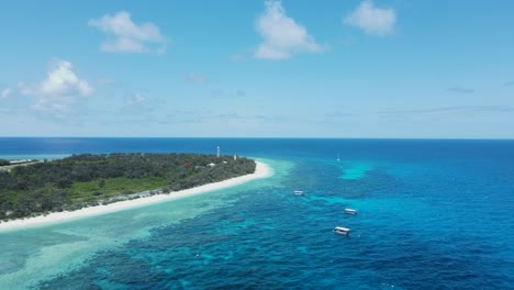 Lush-island-location-surrounded-by-tropical-blue-ocean-waters-and-a-underwater-reef-system