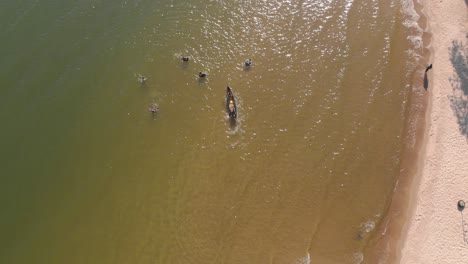 Toma-Aérea-Sobre-Un-Grupo-De-Nadadores-En-Una-Playa-En-El-Lago-Victoria-Uganda