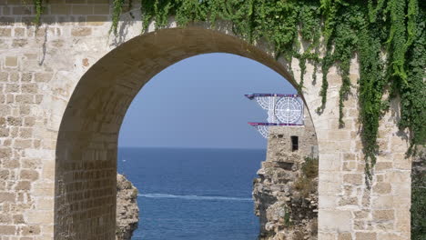 Red-Bull-Cliff-Diving-board-seen-through-Roman-arch-on-sunny-day