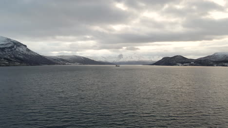 Freezing-winter-weather-in-Norwegian-Arctic-Circle,-drone-flight-over-fjord