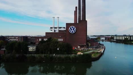 Wolfsburg,-Germany,-June-30,-2022:-aerial-drone-view-of-the-power-plant-of-the-Volkswagen-plant-with-the-large-VW-logo-on-the-side-of-the-brick-building