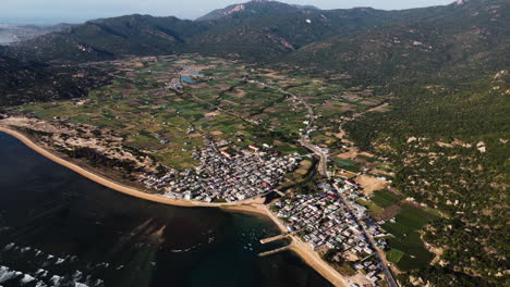 Aerial-seascape-of-fisherman-village-Thai-An-Vietnam-travel-destination-famous-for-vineyard-juicy-grape-wine-production,-drone-fly-above-agricultural-valley-and-hills-in-province-of-Ninh-Thuan