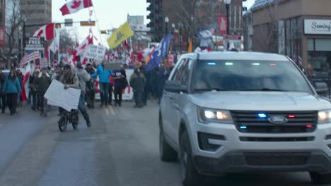 Menschenmenge-Marschiert-Mit-Polizeiauto-Protestiert-In-Calgary-Am-4.-März-2022