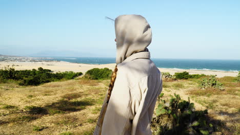 Close-up-shot-of-Woman-wearing-hoodie-during-windy-day-and-watching-beautiful-sand-dunes-and-Ocean-of-Vietnam