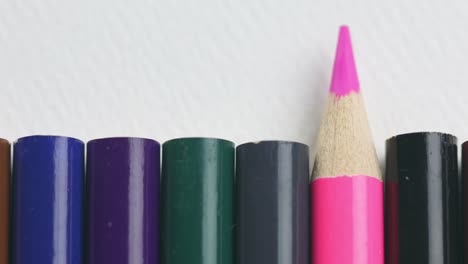 Color-Pencils-On-White-Background,-Pink-Pencil-Stands-Out---close-up,-panning