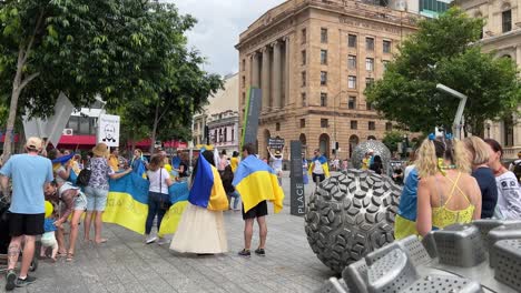 Eine-Große-Gruppe-Von-Menschen-Versammelte-Sich-Am-Brisbane-Square-Mit-Ukrainischer-Flagge,-Bannern-Und-Plakaten,-Um-Ihre-Unterstützung-Für-Das-Ukrainische-Volk-Im-Kriegsgebiet-Zu-Zeigen,-Das-Sein-Heimatland-Vor-Russischer-Gewalt-Schützt