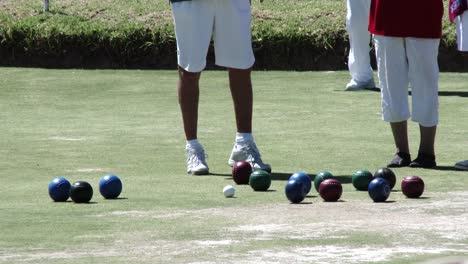 Two-lawn-bowlers-stand-near-the-jack-during-a-club-competition,-close-up