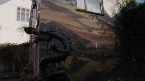 Library-of-Avalon-in-Glastonbury,-dragon-statue-and-murals,-handheld,-day