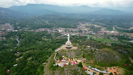 Antena-De-Una-Estatua-De-Jesucristo-En-Tana-Toraja-Sulawesi-En-La-Cima-De-Una-Montaña-Con-Turistas-Y-Tiendas