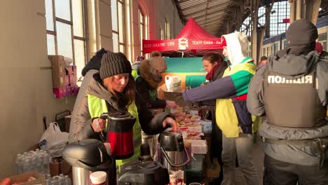 Volunteers-give-hot-tea,-coffee-and-snacks-to-police,-aid-workers-and-refugees-at-the-train-station-in-Lviv,-Ukraine