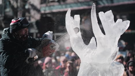 Handheld-shot-of-artist-carving-ice-antlers-with-chainsaw