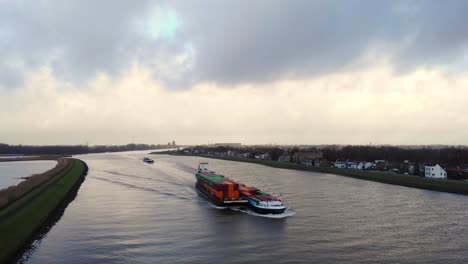 Aerial-View-Of-Circle-Inland-Container-Vessel-Navigation-Along-River-Noord