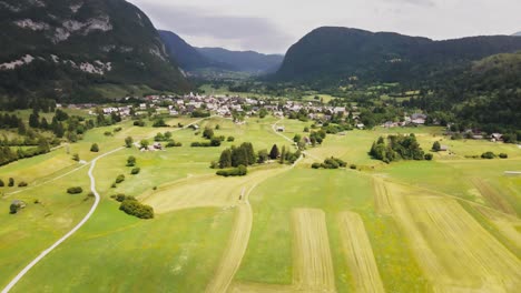 Aerial-view-of-bohinj-lake-the-largest-permanent-lake-in-Slovenia,-drone-fly-above-the-valley-with-little-village