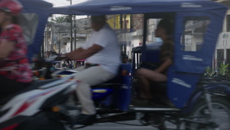 Trikes-at-a-busy-intersection-in-Iquitos,-Peru-on-a-sunny-day